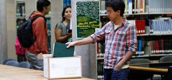 Estudiante depositando libro en caja recolectora